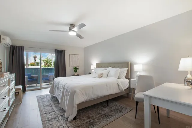 a bedroom with a large bed and a chandelier fan