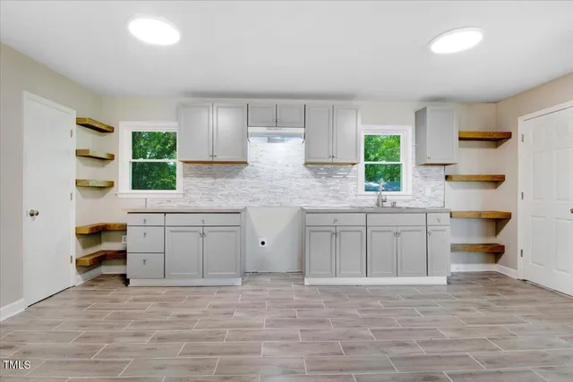 a kitchen with a refrigerator sink and cabinets