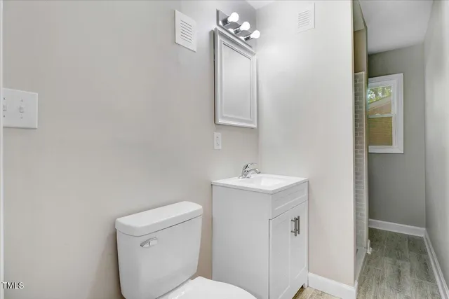 a bathroom with a toilet a sink and mirror