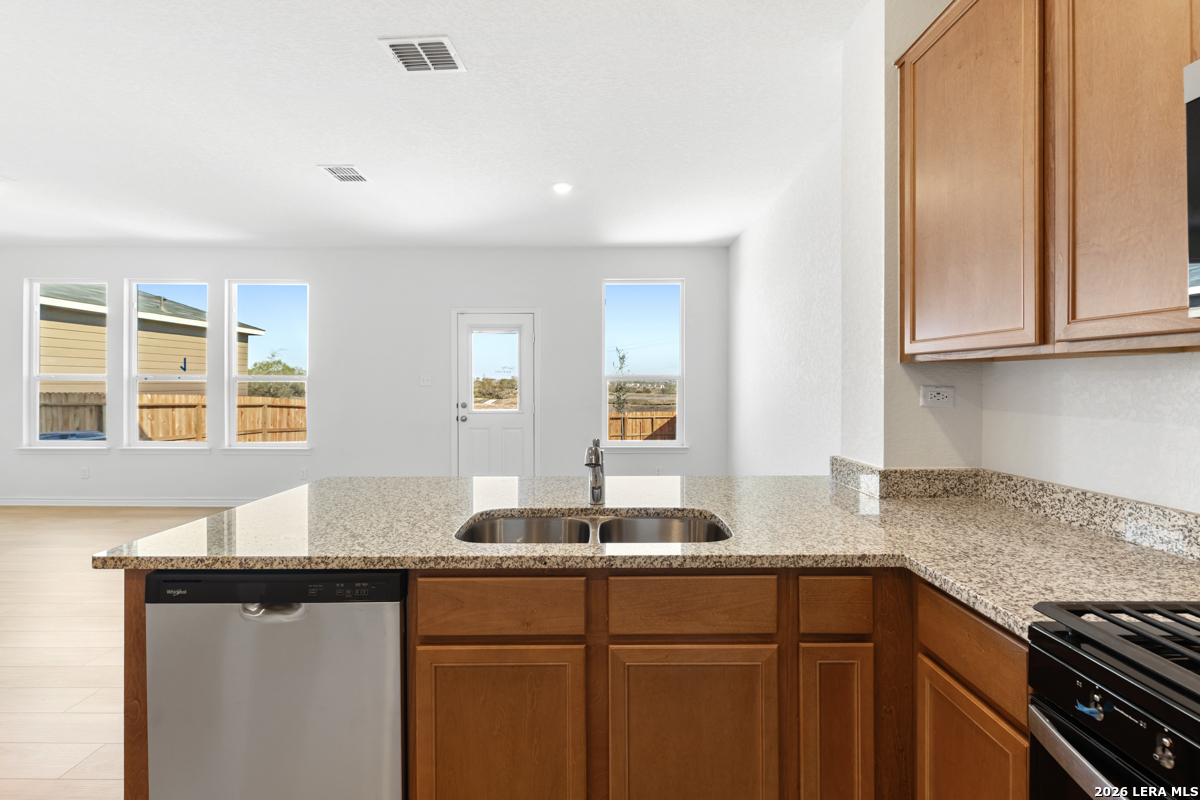 10045 Jagger Avenue Converse, TX 78109 - Photo 15 of 28 a kitchen with granite countertop a sink and cabinets