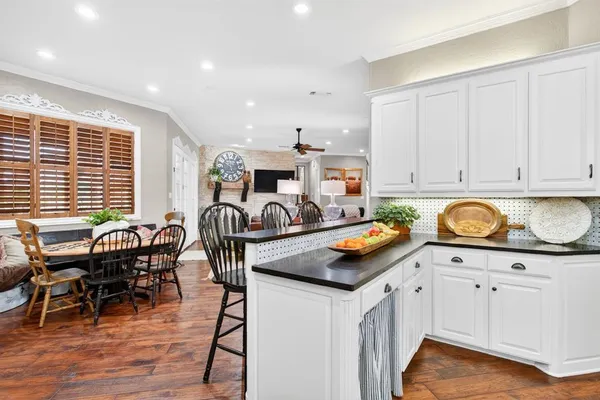 a living room with furniture kitchen view and a window