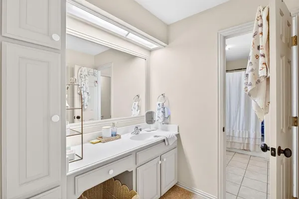 a bedroom with a bed a chandelier and a dresser