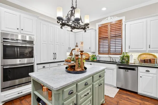 a kitchen with stainless steel appliances granite countertop a stove refrigerator and cabinets