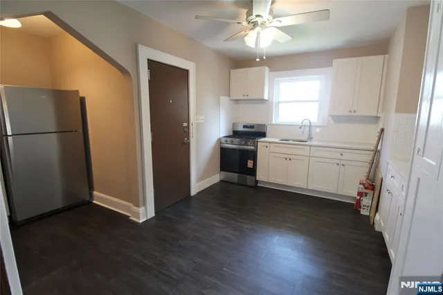 a kitchen with a sink a refrigerator a stove and cabinets