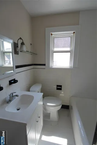 a bathroom with a toilet sink and mirror