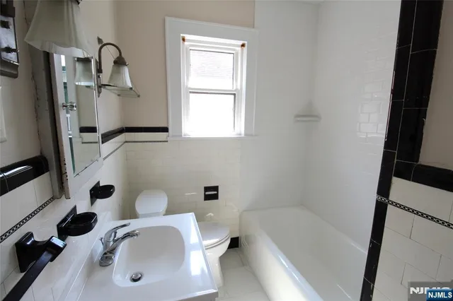 a bathroom with a tub sink and mirror