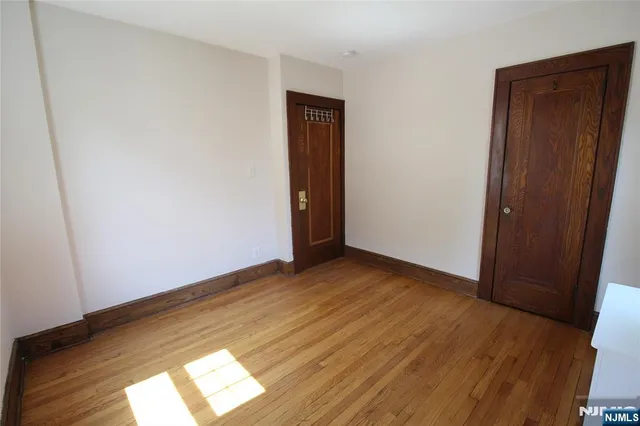 an empty room with wooden floor and closet