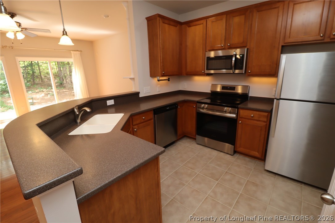 7122 Racine Way Raleigh, NC 27615 - Photo 5 of 32 a kitchen with a sink a stove a refrigerator and a microwave