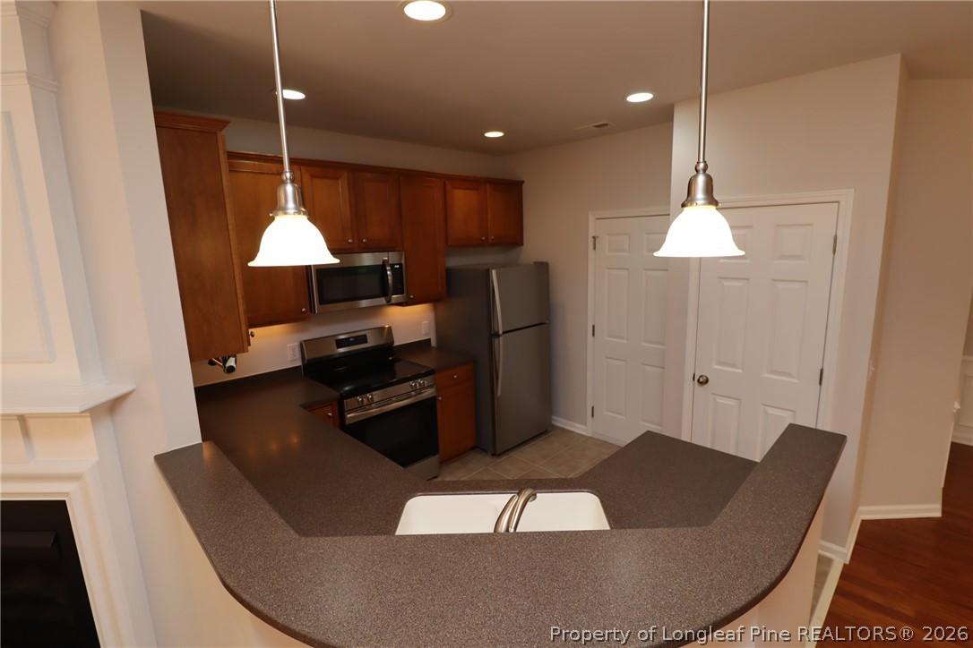 7122 Racine Way Raleigh, NC 27615 - Photo 7 of 32 a kitchen with stainless steel appliances granite countertop a sink a stove and a refrigerator