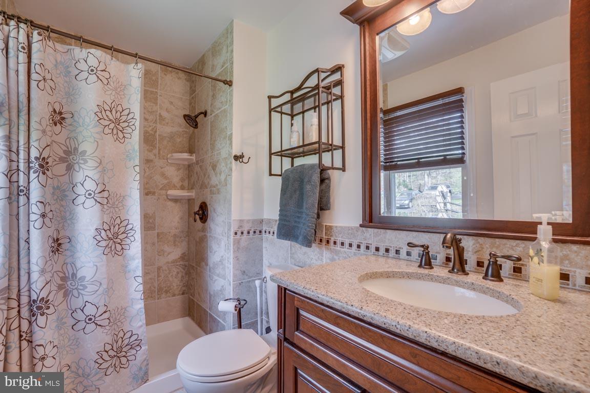 13663 Van Doren Road Manassas, VA 20112 - Photo 17 of 33 a bathroom with a granite countertop sink toilet and shower