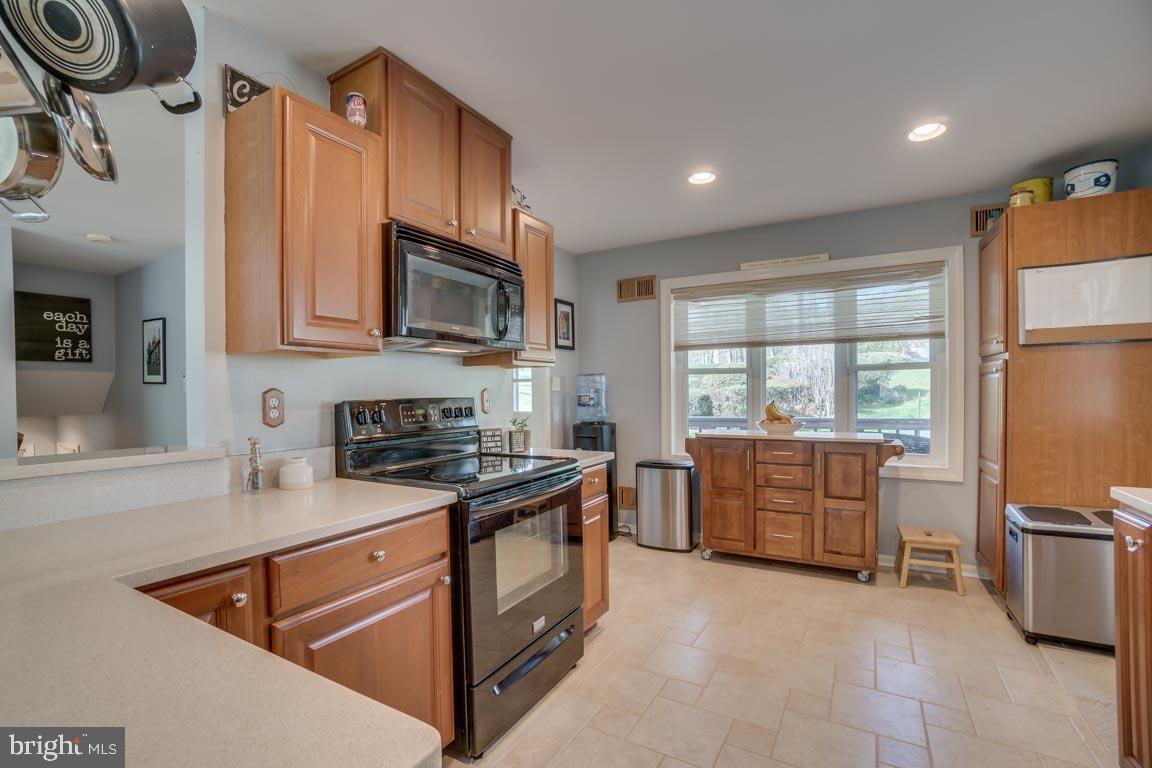 13663 Van Doren Road Manassas, VA 20112 - Photo 8 of 33 a kitchen with granite countertop a stove top oven a sink dishwasher a dining table and chairs with wooden floor