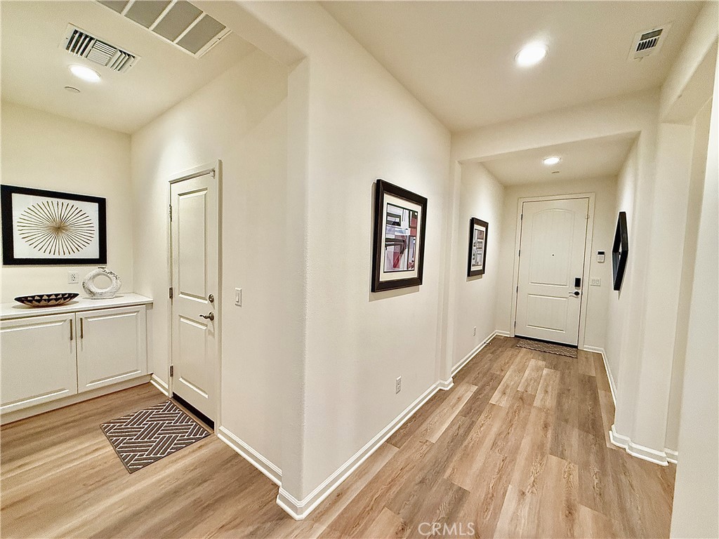 36237 Sunset Ridge Court Wildomar, CA 92595 - Photo 33 of 41 a view of a hallway with wooden floor and a living room