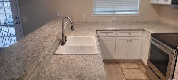 a close view of a sink a faucet and a stove in a kitchen