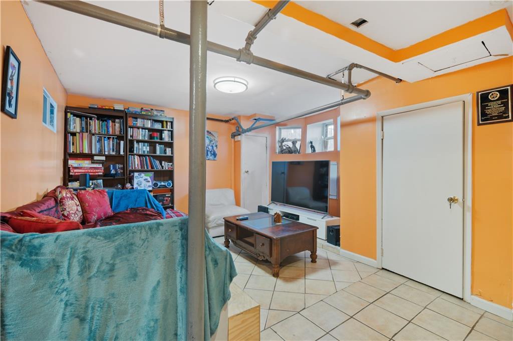 8 Raleigh Place Brooklyn, NY 11226 - Photo 15 of 21 a living room with furniture a flat screen tv and a book shelf