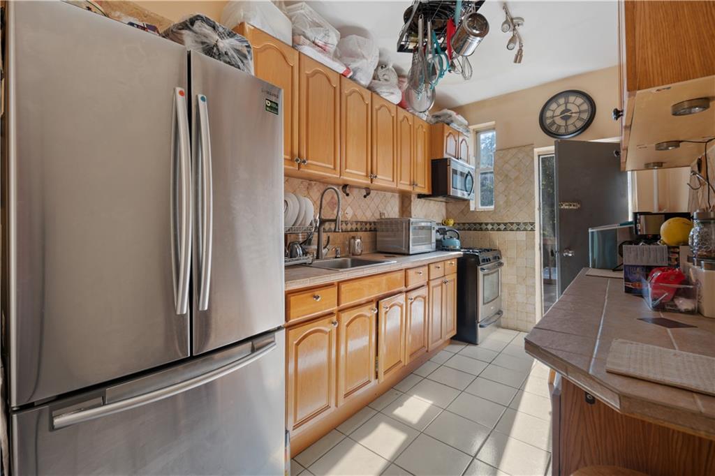 8 Raleigh Place Brooklyn, NY 11226 - Photo 7 of 21 a kitchen with stainless steel appliances granite countertop a refrigerator and a sink