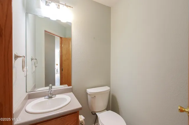 a bathroom with a toilet a sink and mirror
