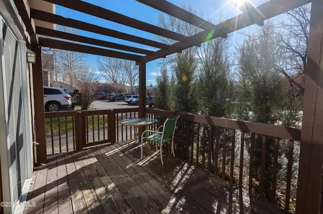 a view of a balcony with chairs and wooden floor