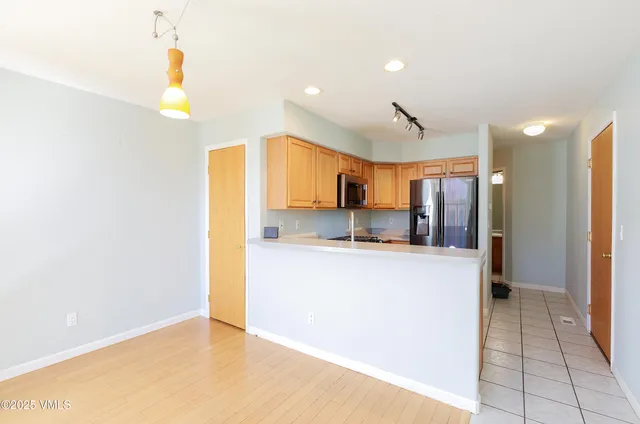 a kitchen with stainless steel appliances a refrigerator and a stove top oven