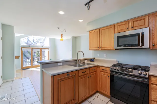 a kitchen with stainless steel appliances granite countertop a sink stove a microwave and wooden cabinets
