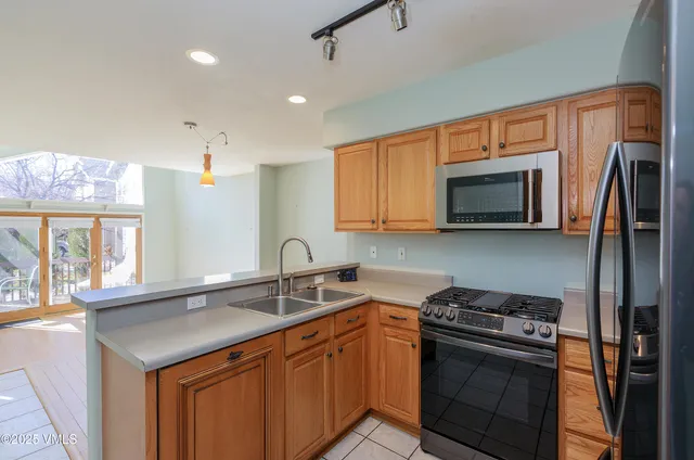 a kitchen with stainless steel appliances a sink stove and microwave