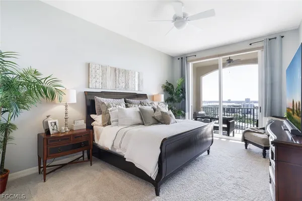 a bedroom with a bed couch and a large window