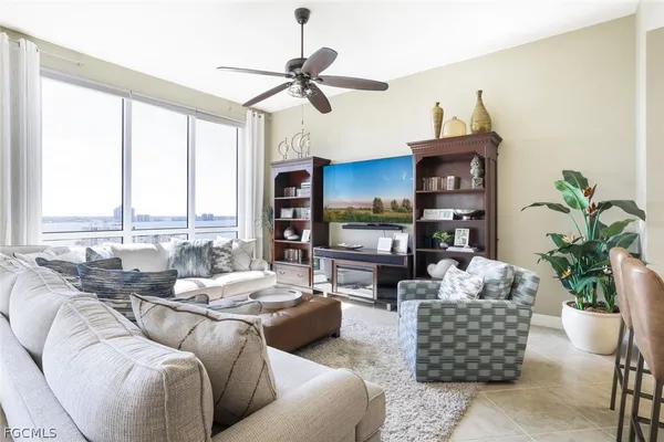 a living room with furniture fireplace and a large window