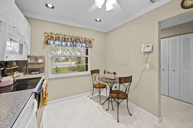 a view of a dining room and livingroom with furniture a rug a painting and a chandelier
