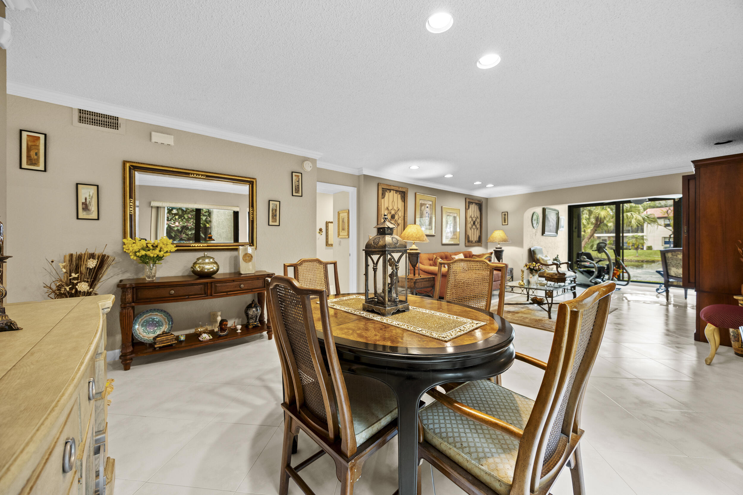 21691 Tall Palm Circle, Unit 3C Boca Raton, FL 33433 - Photo 10 of 48 a view of a dining room and livingroom with furniture a rug a painting and a chandelier
