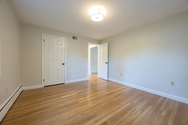 a view of an empty room and wooden floor