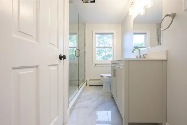 a bathroom with a sink a toilet and shower