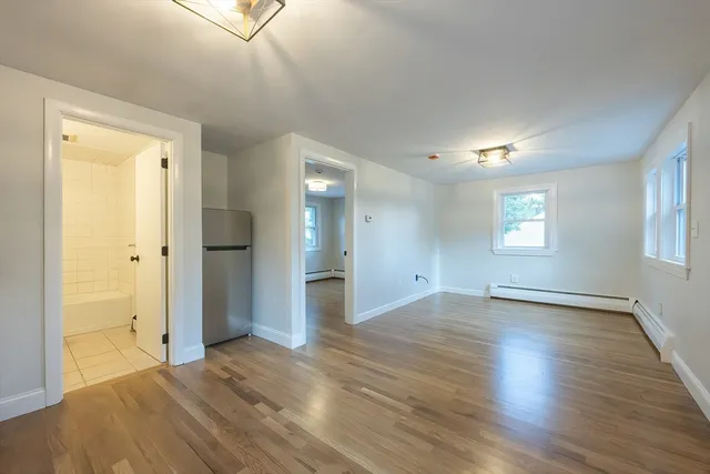 a view of an empty room and window and wooden floor