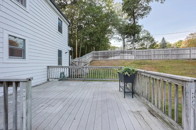 a view of a balcony with wooden floor next to a yard