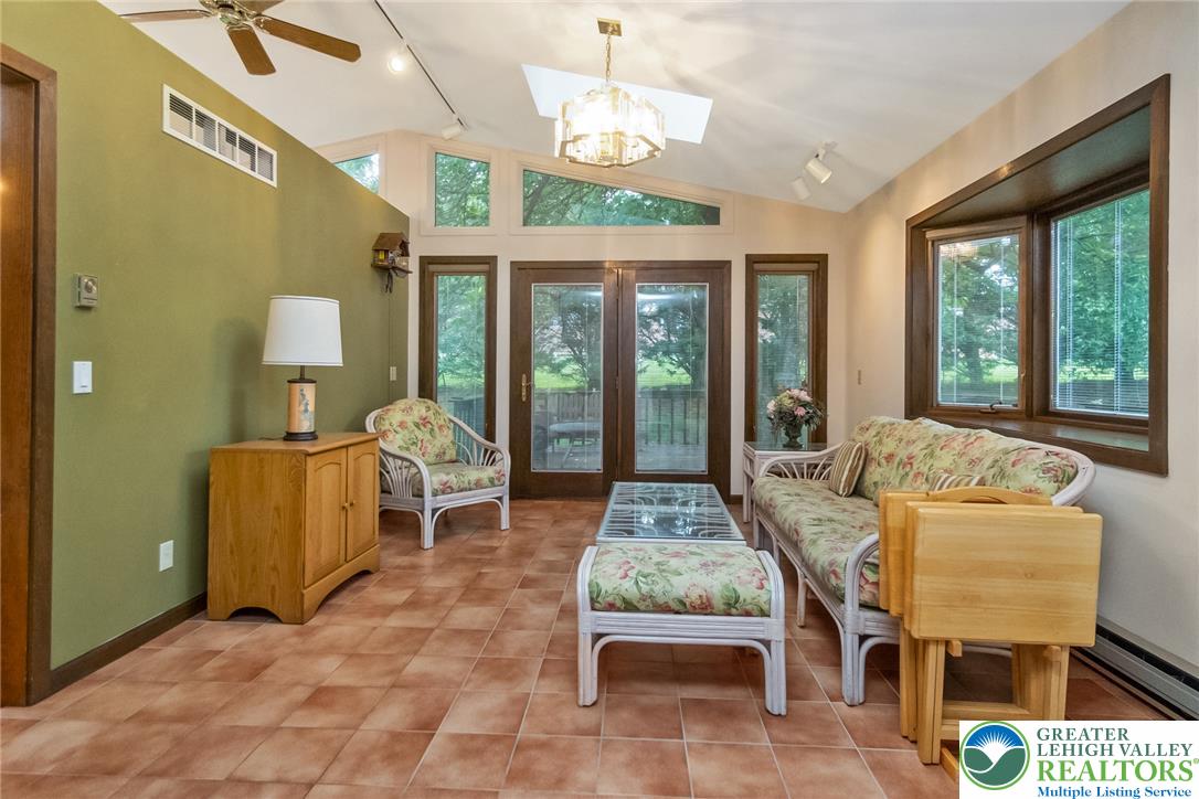 1328 Russett Road Allentown, PA 18104 - Photo 17 of 46 A well-lit sunroom boasts tile flooring, a skylight, and direct patio access for indoor-outdoor living.