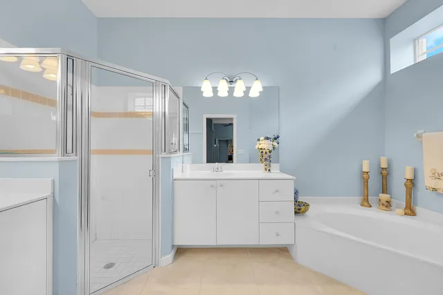 a bathroom with a tub sink and mirror