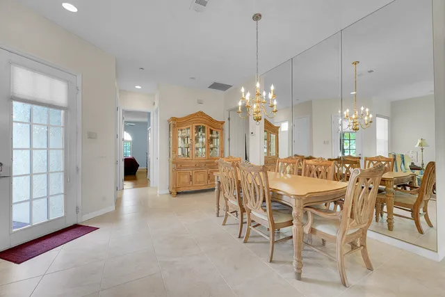 a dining room with furniture a chandelier and kitchen view
