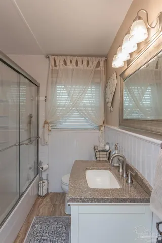 a en suite bathroom with a granite countertop sink and a mirror
