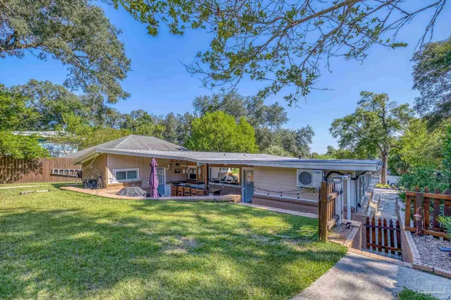 a view of a backyard with plants and brick wall