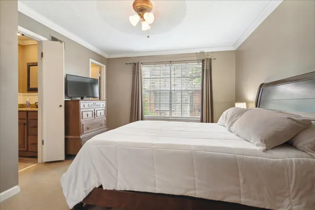 a bedroom with a large bed and a flat tv screen