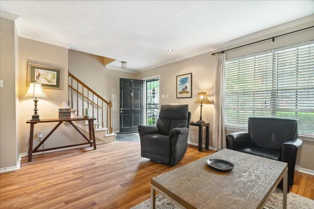 a living room with furniture and a wooden floor