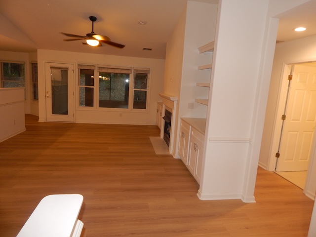 620 Downs Loop Clemson, SC 29631 - Photo 5 of 35 Warm wood-style flooring and built-in shelving complement the open living area.