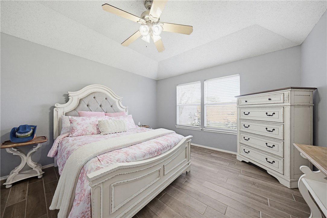 1004 La Mirada Portland, TX 78374 - Photo 19 of 23 a spacious bedroom with a bed and a chandelier