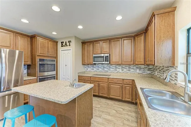 a kitchen with stainless steel appliances granite countertop a sink stove and refrigerator