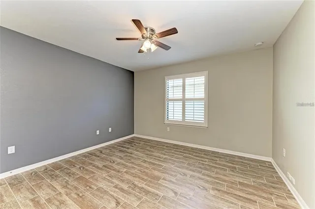 a view of an empty room with window and wooden floor