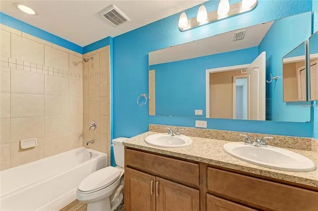 a bathroom with a sink a toilet tub and shower