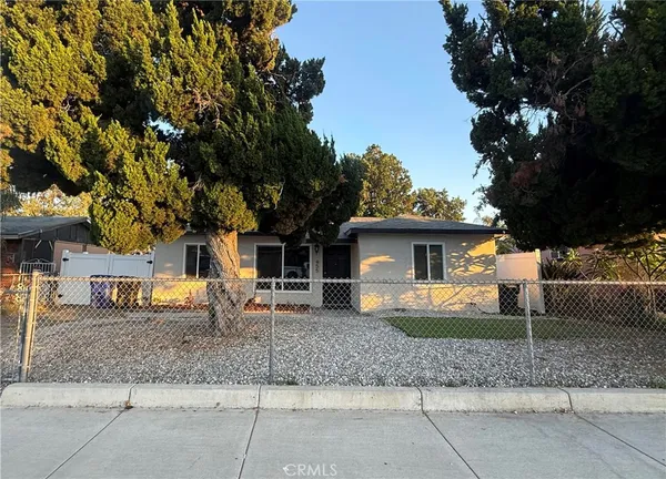 a view of a house with a backyard and a tree