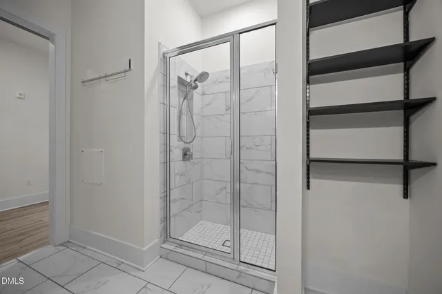a view of a hallway with wooden floor and closet