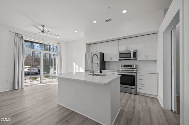 a kitchen with stainless steel appliances a refrigerator and a stove top oven