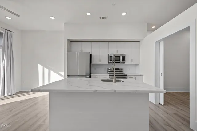 a view of kitchen with stainless steel appliances refrigerator microwave and stove