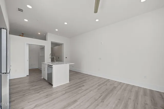 a view of a livingroom with wooden floor and a ceiling fan