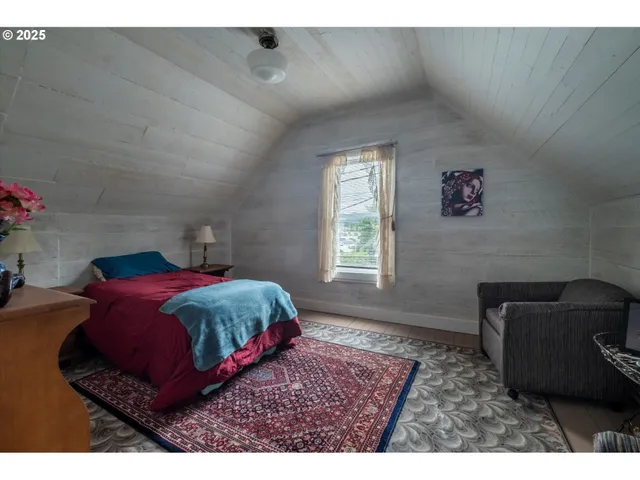 a bedroom with a bed a couch and a window